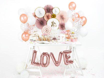 Ozdobiony stół urodzinowy i balony literki w kolorze różowego złota
