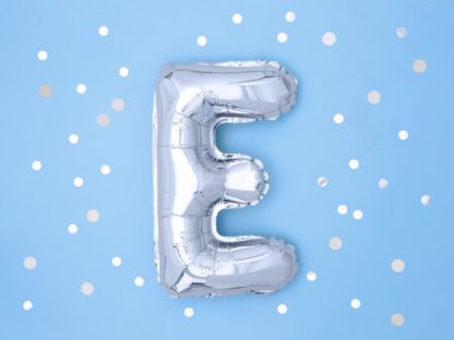 Srebrny balon foliowy w kształcie litery E na niebieskim tle