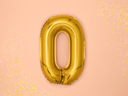 Złoty balon foliowy w kształcie litery O na różowym tle