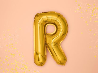 Złoty balon foliowy w kształcie litery R na różowym tle