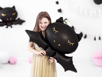 Dziewczynka z balonem foliowym w kształcie nietoperza