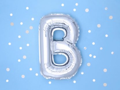 Srebrny balon foliowy w kształcie litery B na niebieskim tle