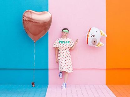 Dziewczyna z balonami foliowymi w kształcie serca i psa