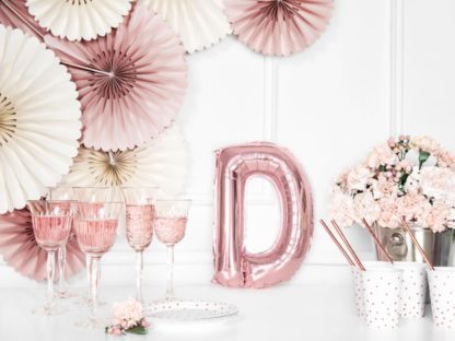 Różowe złoto balon foliowy w kształcie litery D na stole